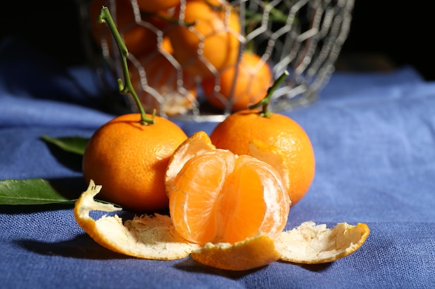 Tangerinas maduras suculentas com folhas na toalha de mesa