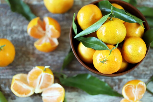 Tangerinas suculentas maduras em uma tigela. folhas de tangerina.