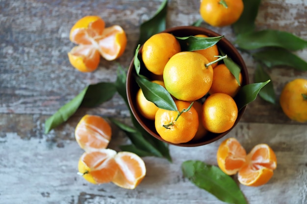 Tangerinas suculentas maduras em uma tigela. Folhas de tangerina.