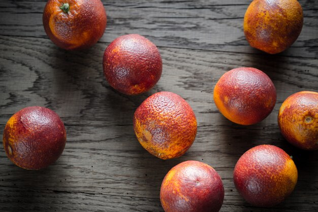 Tangerinas vermelhas sobre o fundo de madeira