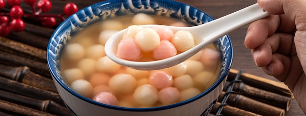 Foto tangyuan rojo y blanco con sopa de almíbar