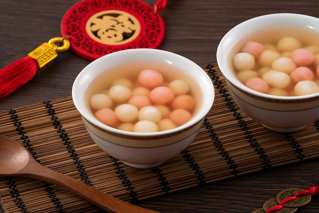 Foto tangyuan rojo y blanco con sopa de jarabe