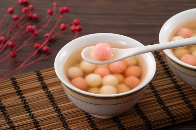 Foto tangyuan rojo y blanco con sopa de jarabe