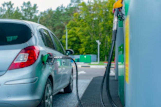 Tankstelle bei Nacht Das Auto wird mit Benzin betankt Unscharfes Foto für den Hintergrund