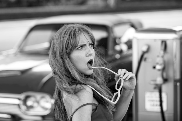 Tankstelle sinnliche Frau gegen rotes Retro-Auto