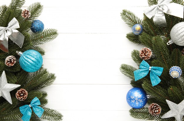 Tannenbaumaste mit silberner und blauer Weihnachtsdekoration auf einem weißen Hintergrund