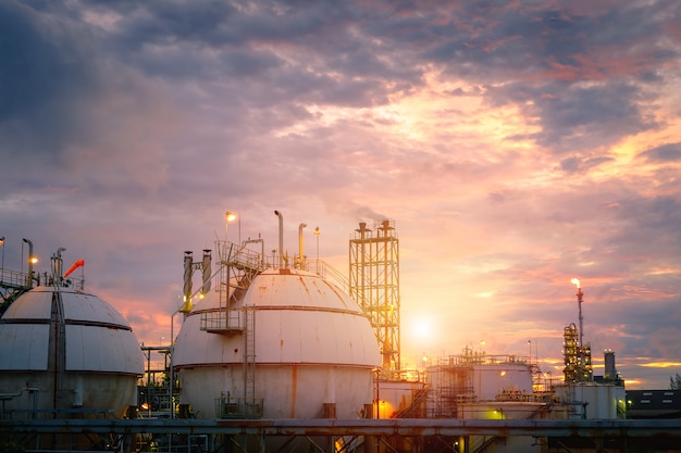 El tanque de almacenamiento de gas de la refinería al atardecer