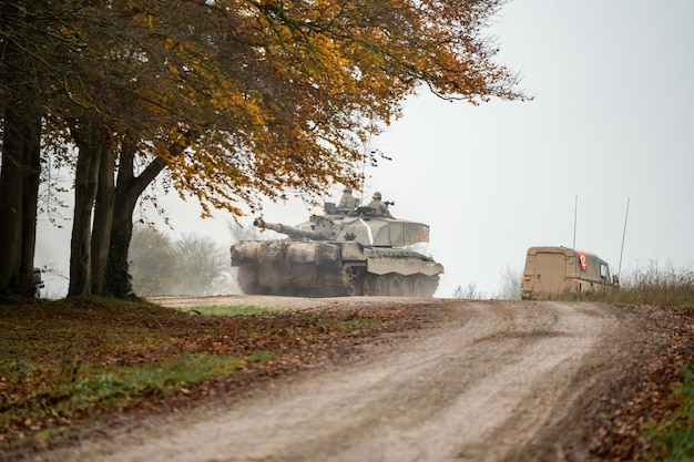 Foto tanque militar y soldados con armas en un campo