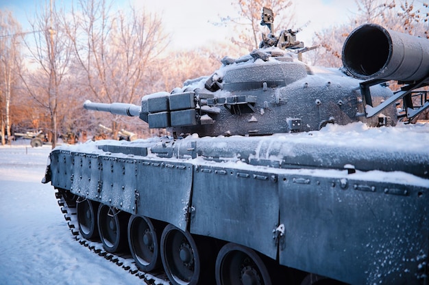 Tanque bajo la nieve en el bosque Camuflaje de tanque de invierno Tanque de batalla en la nieve al borde de la carretera Guerra en Ucrania en invierno