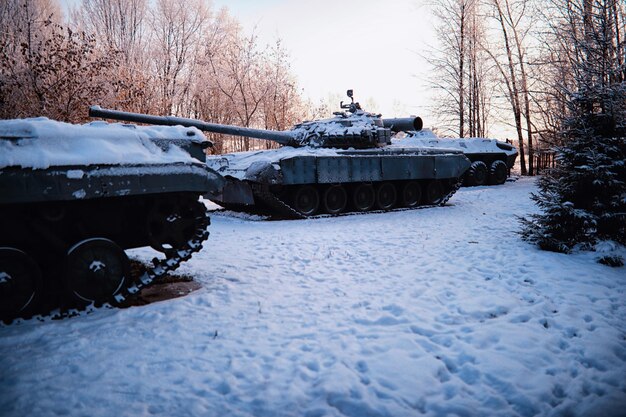 Tanque bajo la nieve en el bosque Camuflaje de tanque de invierno Tanque de batalla en la nieve al borde de la carretera Guerra en Ucrania en invierno