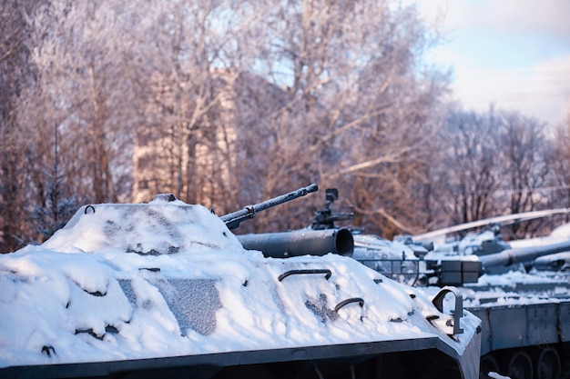 Tanque bajo la nieve en el bosque Camuflaje de tanque de invierno Tanque de batalla en la nieve al borde de la carretera Guerra en Ucrania en invierno