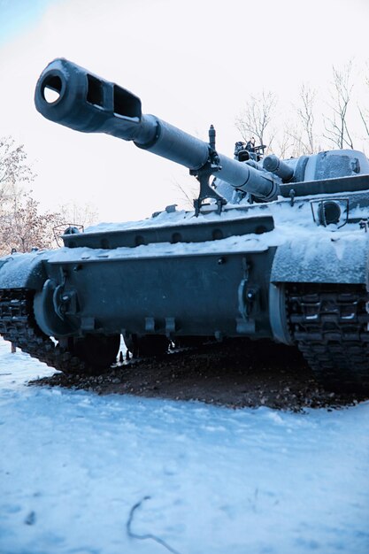 Tanque sob a neve na floresta Camuflagem de tanque de inverno Tanque de batalha na neve na beira da estrada Guerra na Ucrânia no inverno