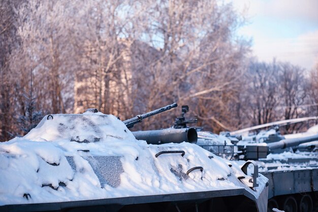 Tanque sob a neve na floresta Camuflagem de tanque de inverno Tanque de batalha na neve na beira da estrada Guerra na Ucrânia no inverno