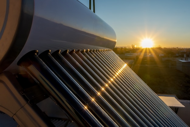 Foto tanque solar de água quente ao pôr do sol