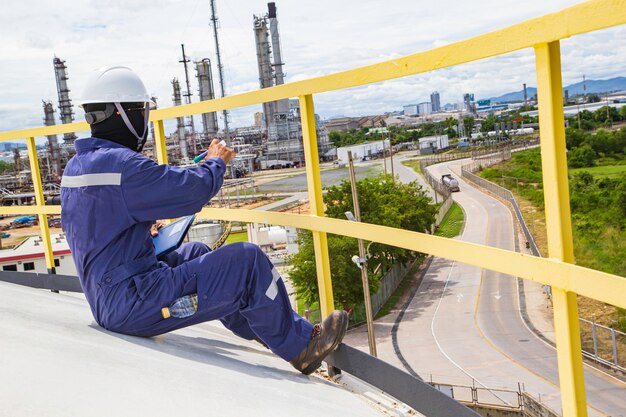 Tanque visual de inspección de trabajador masculino y gasoducto de petróleo