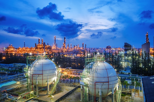 Tanques de esfera de armazenamento de gás e oleoduto na planta industrial de refinaria de petróleo e gás com propriedade de indústria de iluminação de brilho no crepúsculo