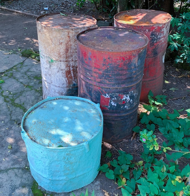 tanques enferrujados ou barril ou galão ou recipiente no quintal para petróleo e perigo