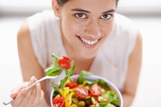 Tanta bondade fresca Retrato de alto ângulo de uma jovem atraente comendo uma tigela de salada