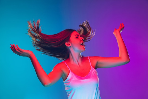 Tanzendes Haar weht inspiriert kaukasische junge Frau Porträt auf Farbverlauf Hintergrund