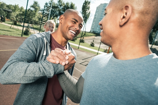 Foto tão feliz de vê-lo. homem afro-americano alegre cumprimentando seu melhor amigo e, ao mesmo tempo, feliz em vê-lo