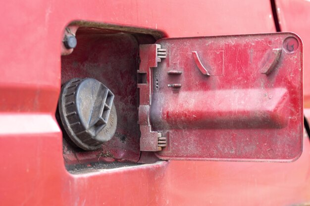 La tapa abierta del tanque de combustible del automóvil se abrió para verter gasolina o combustible diesel en el tanque a una velocidad de gas