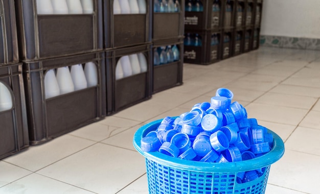 Tapa de botella de agua de plástico azul Un montón de montones juntos en una cesta de plástico en la fábrica de agua potable