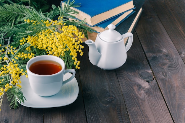 Tapa de té y libro sobre la mesa