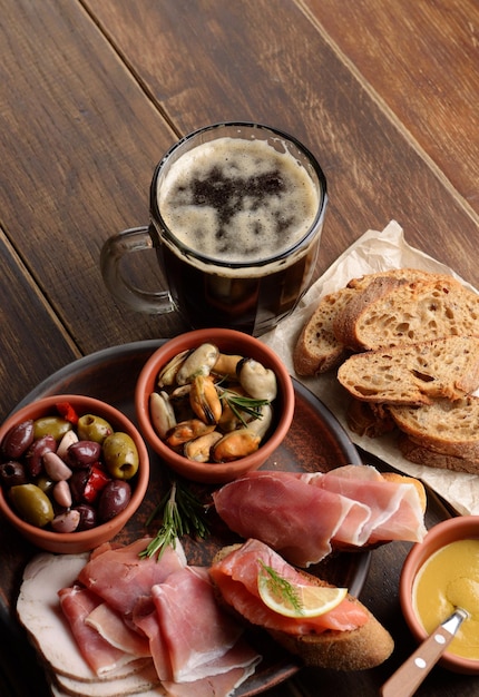 Tapas aus Lachsmuscheln Jamon und Oliven mit Bier