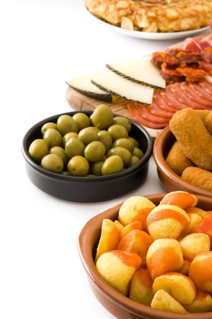 Foto tapas españolas tradicionales con croquetas, aceitunas, jamón y patatas bravas en blanco