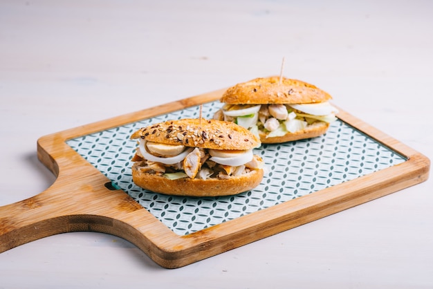 Tapas de pollo y ensalada con mini baguette de huevo y mayonesa.