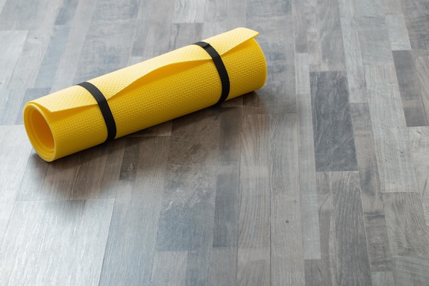 Tapete de fitness no chão de madeira em casa