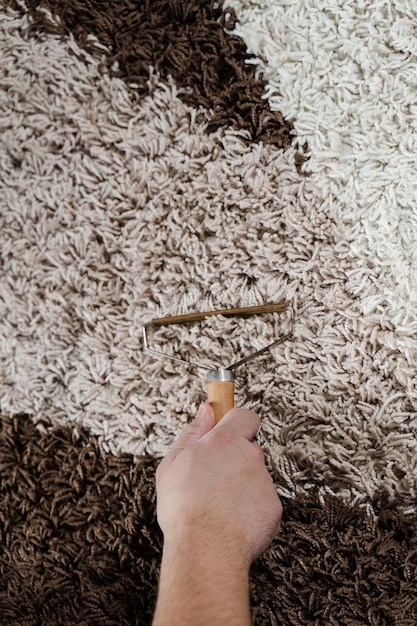 Foto tapete de limpeza usando removedor de fiapos portátil removedor de pêlos de cães e gatos reutilizável com navalha raspador de carpete manual closeup