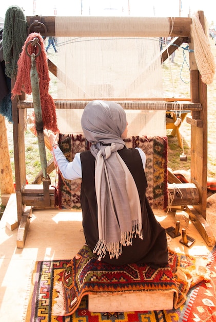 Tapete de tipos tradicionais feito em tear e menina