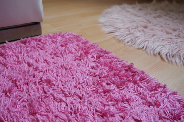 Tapete longo em rosa sobre piso laminado bege Interior feminino para um quarto ou quarto de uma menina ou mulher Design de interiores em tons de rosa O piso é laminado O papel dos ácaros nas alergias