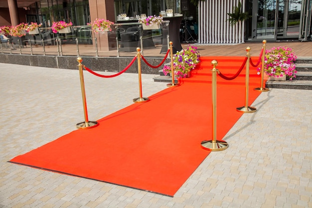 Tapete vermelho com cerca dourada na entrada do restaurante