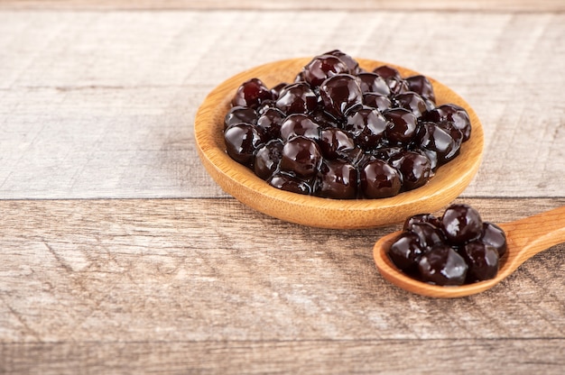 Tapioca Pearl, cobertura de burbujas para té u otra bebida, en una taza, colóquela sobre la mesa de madera. Copia espacio