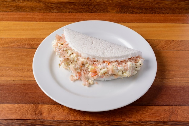 Tapioca en plato blanco sobre mesa de madera comida brasileña