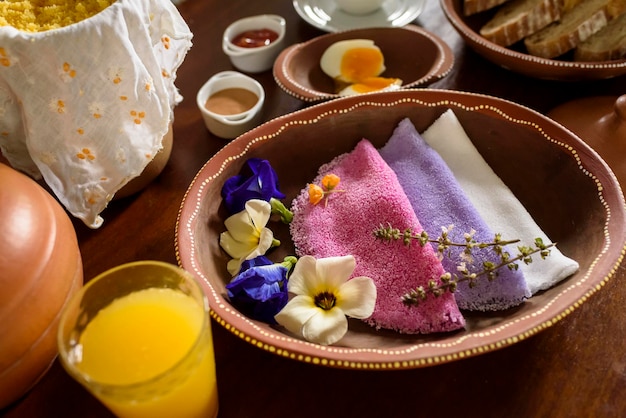 Tapioka Bunte brasilianische Tapiokas, serviert in Tonschalen mit Wildblumen zum Frühstück