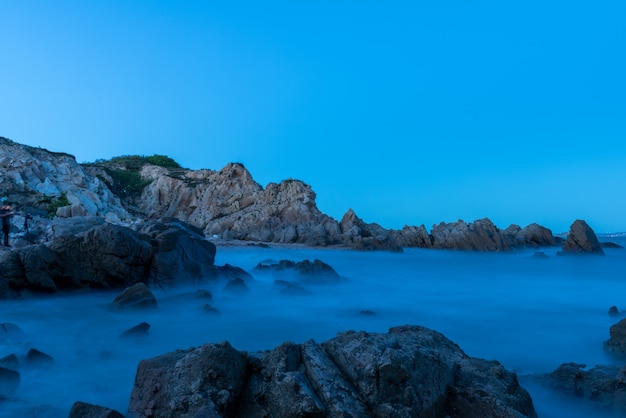 Foto por la tarde, el mar golpeó las rocas