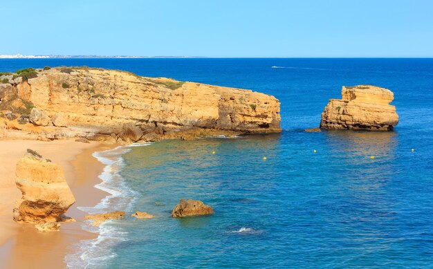 Tarde de verano con vistas a la costa rocosa del Atlántico y la playa de arena Praia de Sao Rafael con acantilados de piedra caliza, Albufeira, Algarve, Portugal).