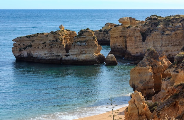 Tarde de verano con vistas a la costa rocosa del Atlántico y la playa de arena Praia de Sao Rafael con acantilados de piedra caliza, Albufeira, Algarve, Portugal).