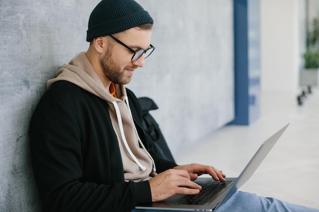 Tarefa urgente Um homem está sentado no chão com um laptop