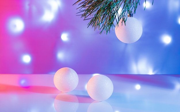 Tarjeta de año nuevo bolas blancas brillantes sobre un fondo luminoso multicolor brillante