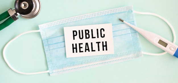 Tarjeta blanca con la inscripción salud pública en una máscara protectora médica
