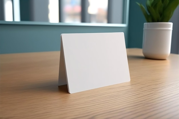 Foto una tarjeta blanca sobre una mesa con una planta al fondo.