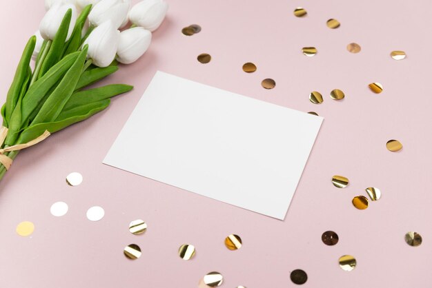 Una tarjeta blanca con tulipanes sobre un fondo rosa con una tarjeta blanca que dice tulipanes.