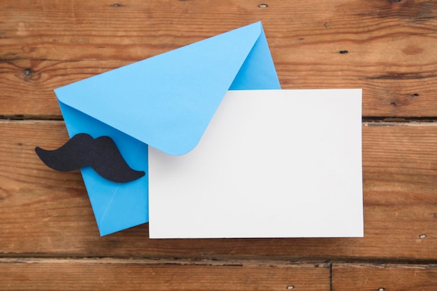 Tarjeta en blanco del día del padre y sobre azul con bigote de papel