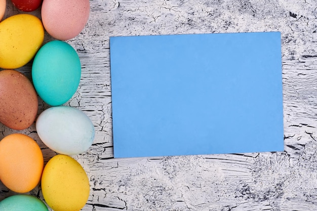 Foto tarjeta en blanco de huevos de pascua coloridos papel vacío en madera