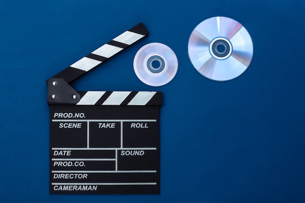 Tarjeta de chapaleta de película y cd sobre fondo azul clásico. Industria del cine, entretenimiento. Vista superior