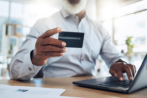 Tarjeta de crédito comercial de hombre y manos en la computadora portátil para finanzas de comercio electrónico o contabilidad en la oficina Computadora de trabajador de primer plano y pago financiero de comercio fintech de presupuesto o economía digital en línea